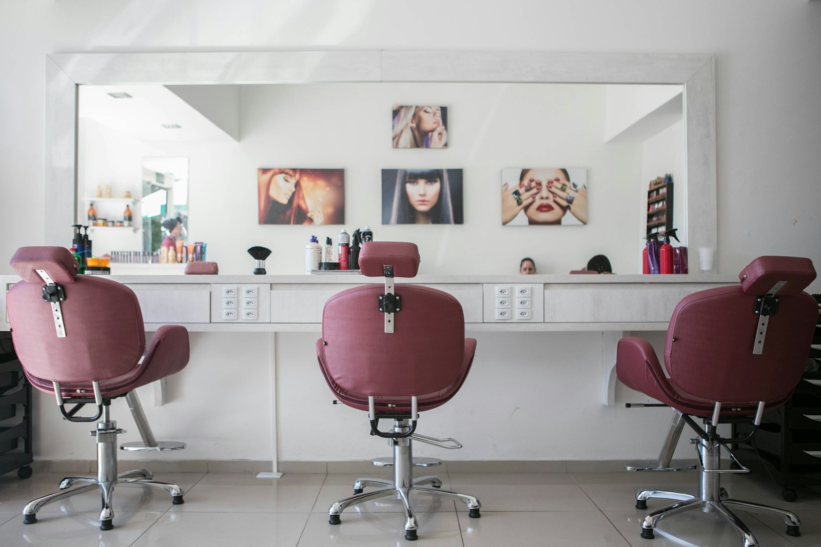 Studio de beleza moderno com cadeiras, espelhos iluminados e bancada de maquiagem